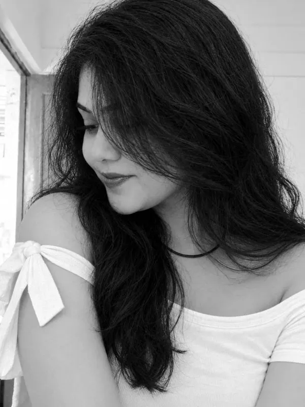 Black and white portrait of Manu by the window.