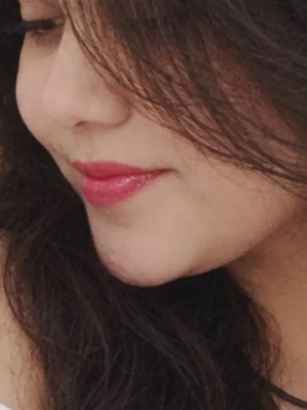 Manu smiling to herself, eyes lowered. The favourite frame.